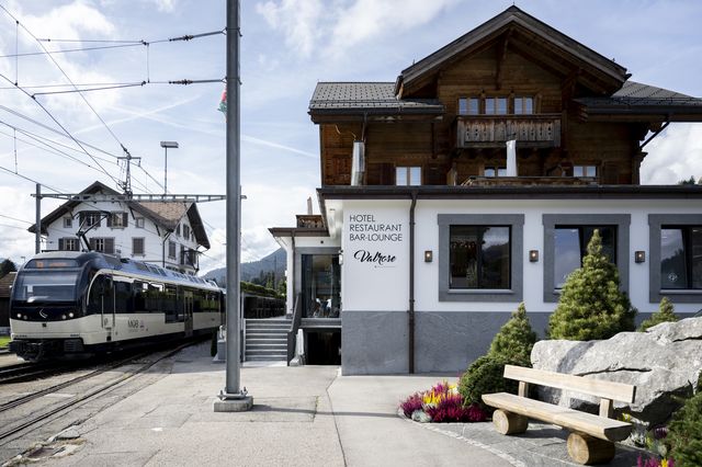 Un train de la compagnie du Montreux Oberland bernois (MOB) passe à côté de l'hôtel-restaurant "Valrose" à Rougemont. [Anthony Anex - Keystone]