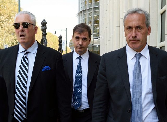 Alejandro Burzaco, entouré de ses deux avocats, à la sortie d'un tribunal de Brooklyn. [Don Emmert - AFP]